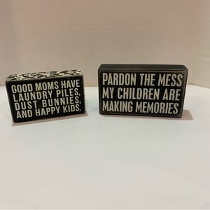 Primitives by Kathy mom focused wooden signs. Black signs with white writing.